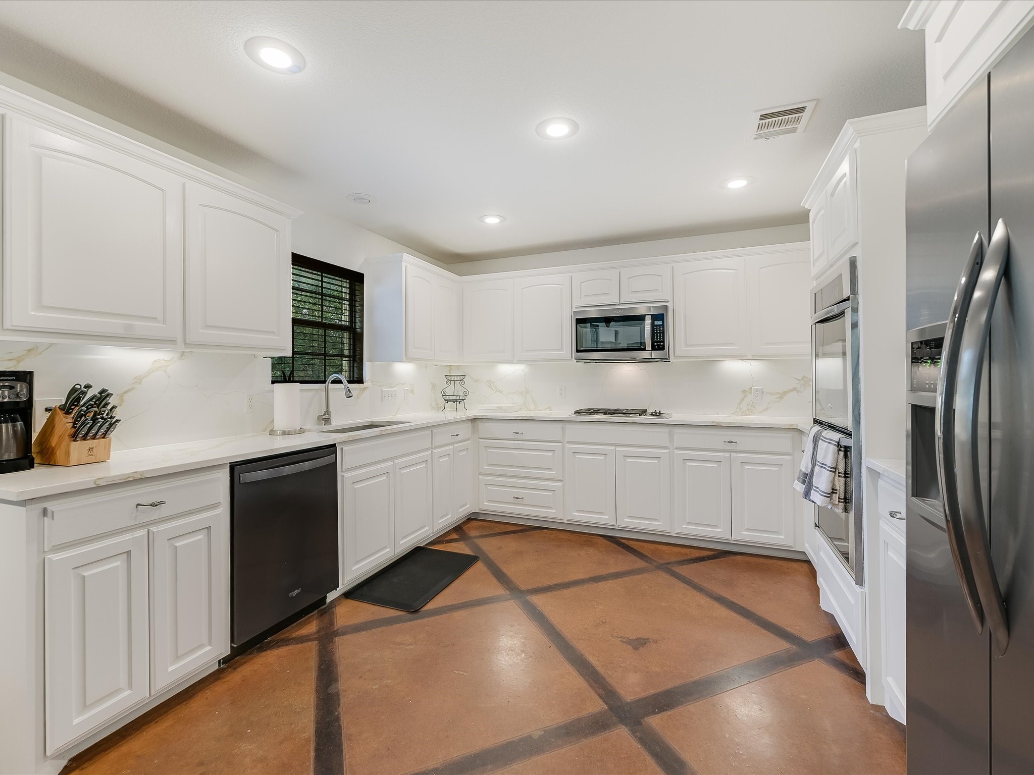 15214 Nightingale Lane Austin, TX 78734 - Photo 7 of 28 a kitchen with white cabinets and refrigerator