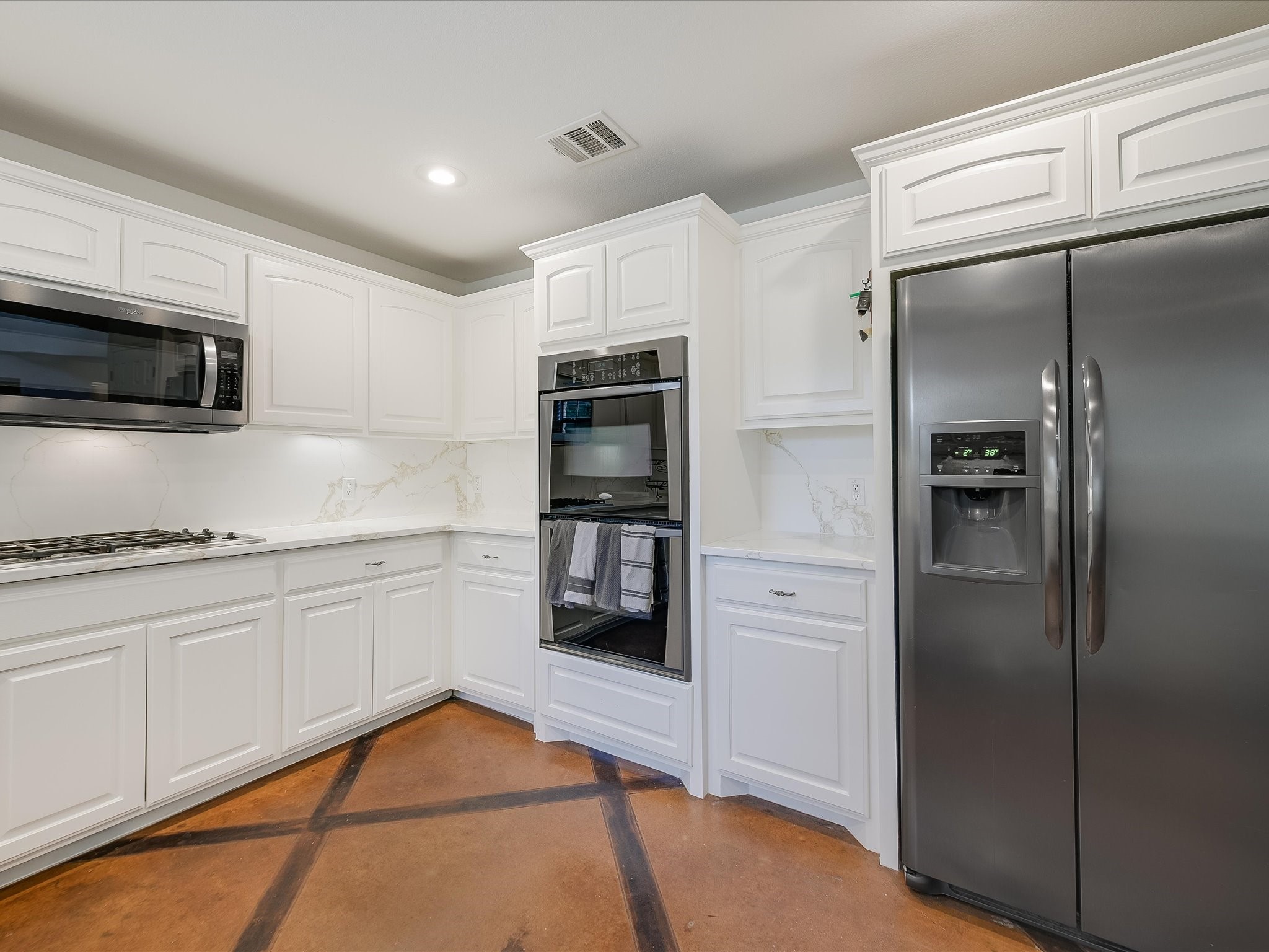 15214 Nightingale Lane Austin, TX 78734 - Photo 8 of 28 a kitchen with granite countertop a refrigerator and a stove top oven
