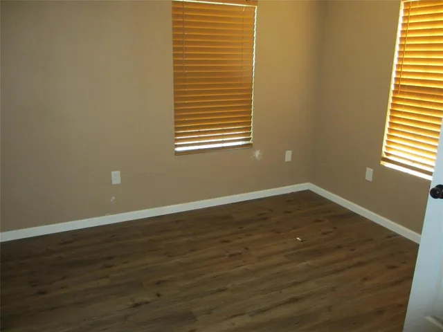a view of a room with wooden floor and a window