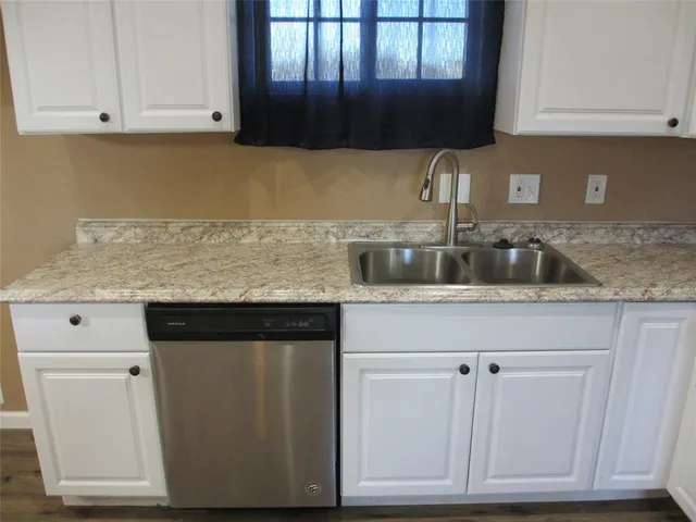 a kitchen with granite countertop a sink and cabinets