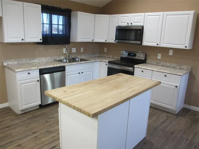 a kitchen with stainless steel appliances granite countertop a stove a sink and a microwave