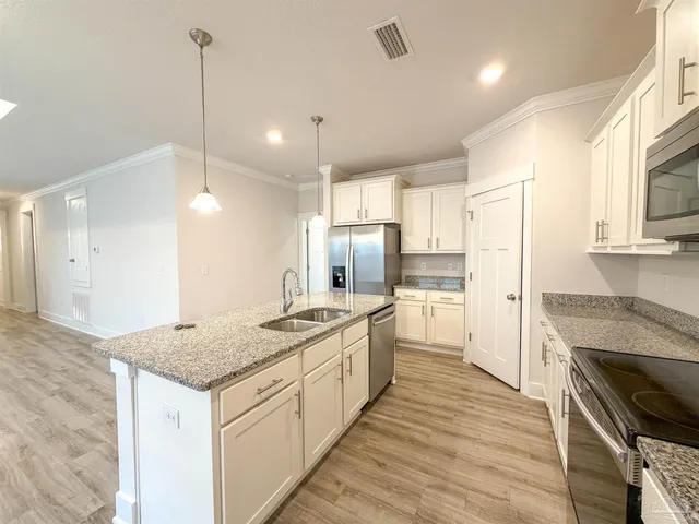 a kitchen with stainless steel appliances granite countertop a sink stove and refrigerator