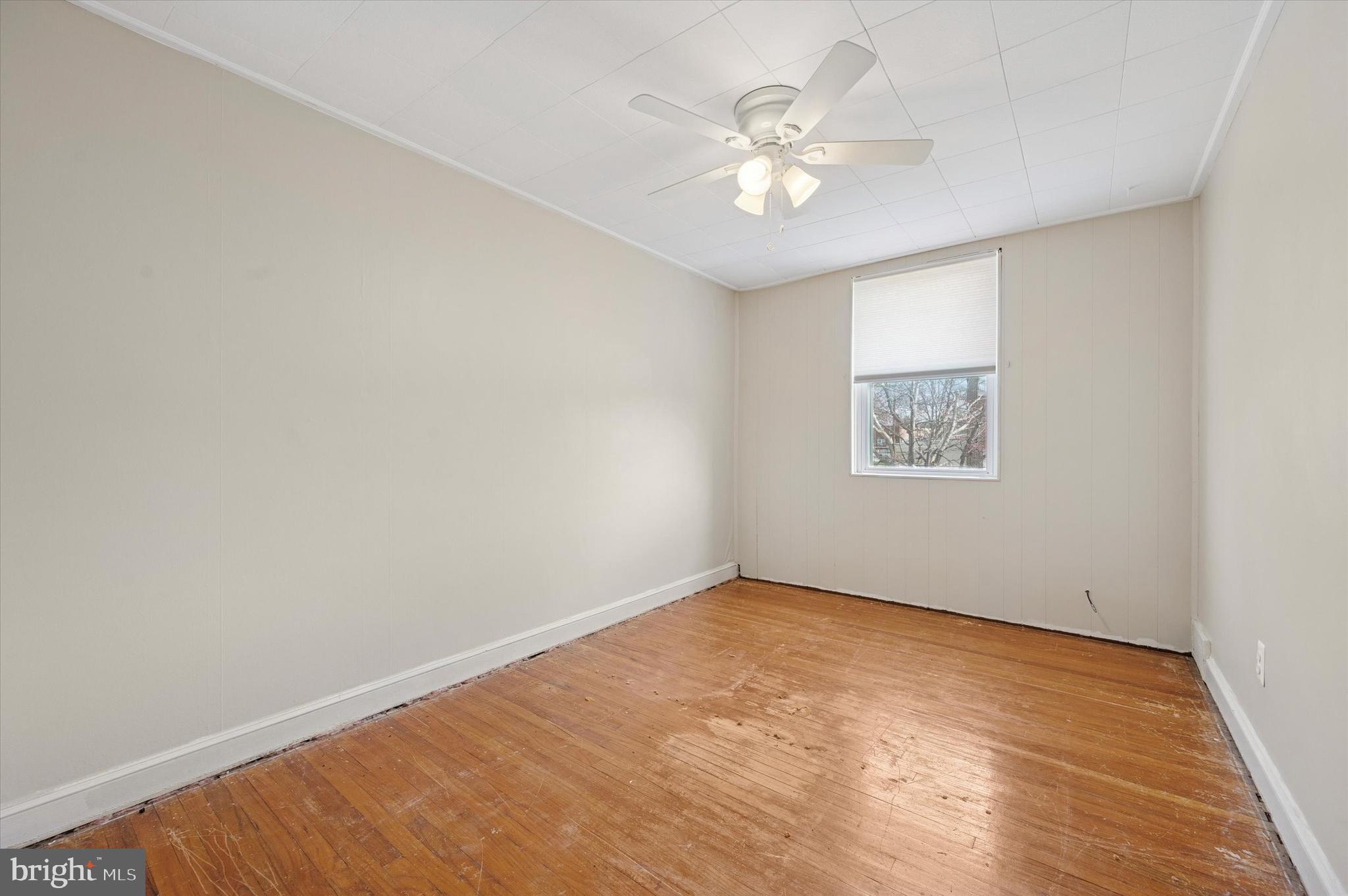 1075 Stratford Road Glenolden, PA 19036 - Photo 11 of 15 an empty room with a chandelier fan and windows