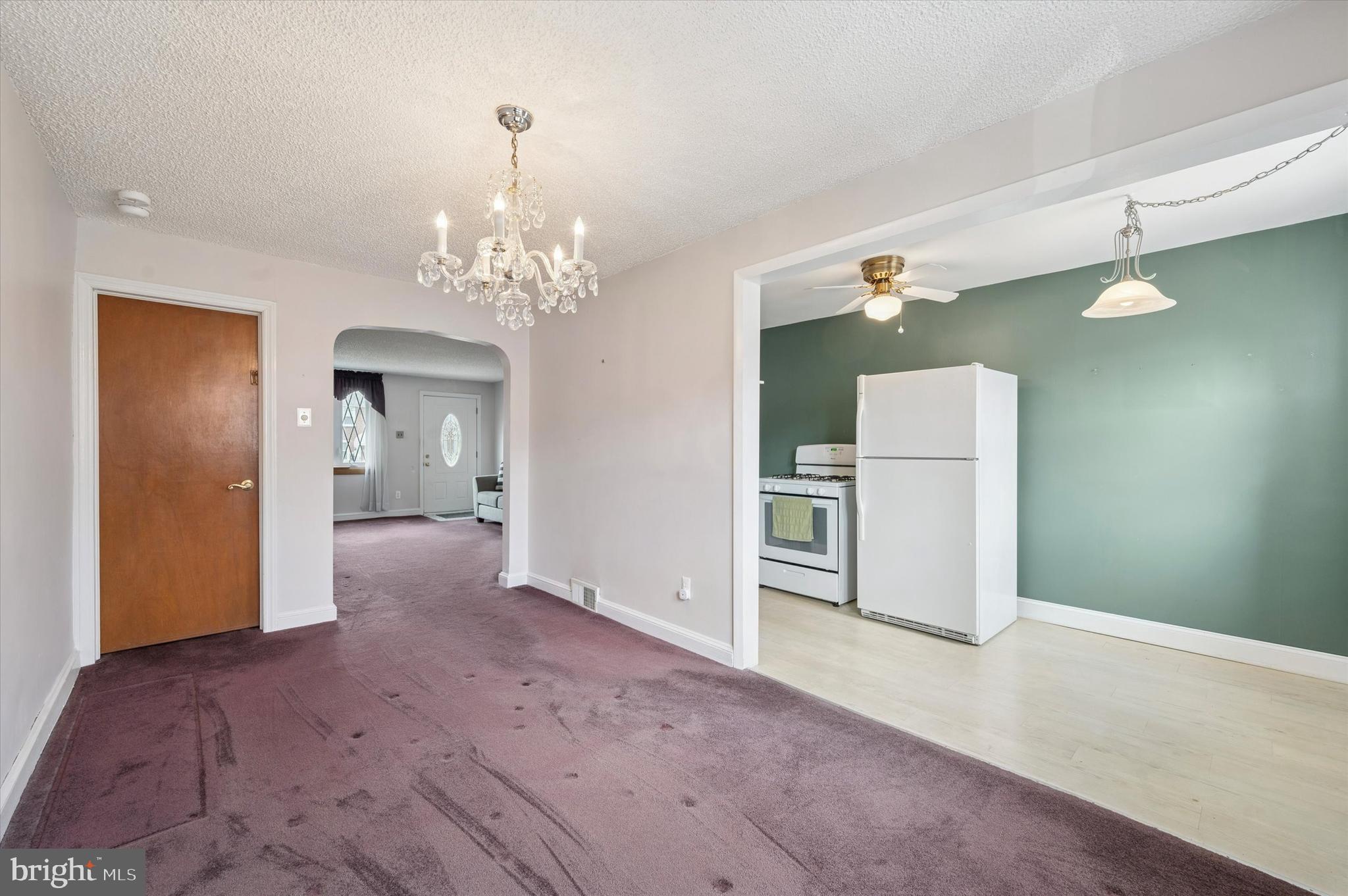 1075 Stratford Road Glenolden, PA 19036 - Photo 6 of 15 an empty room with chandelier and wooden floor