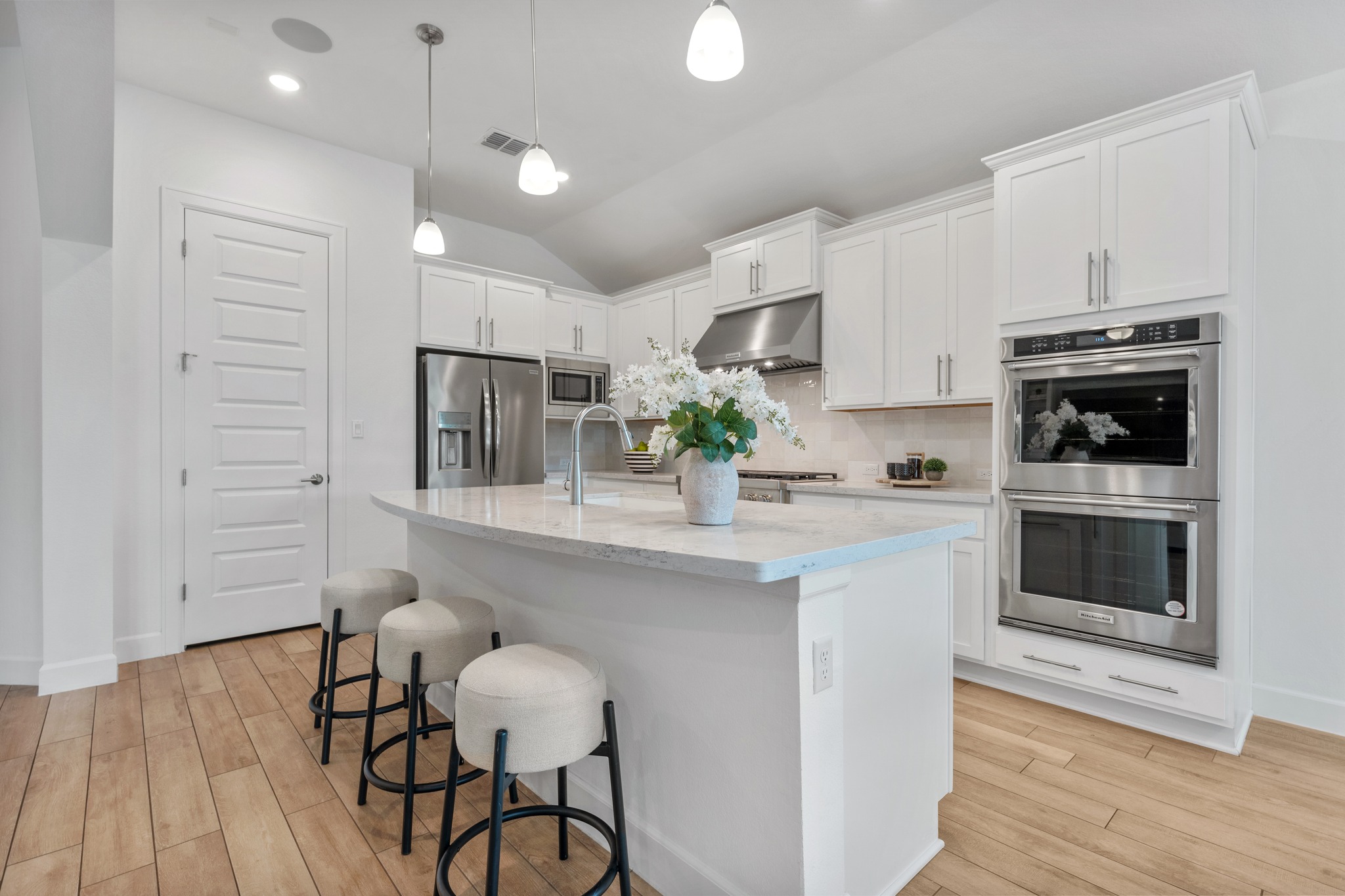 606 Bonfisk Bend Austin, TX 78738 - Photo 11 of 40 a kitchen with kitchen island granite countertop a sink cabinets and wooden floor
