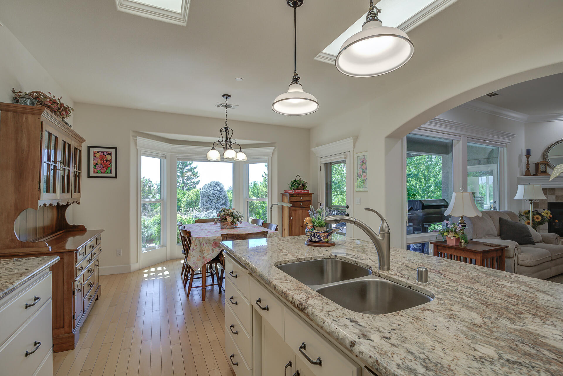 2000 Princeton Way Redding, CA 96003 - Photo 16 of 60 a kitchen with granite countertop a stove a sink a refrigerator dining table chairs and couches with wooden floor