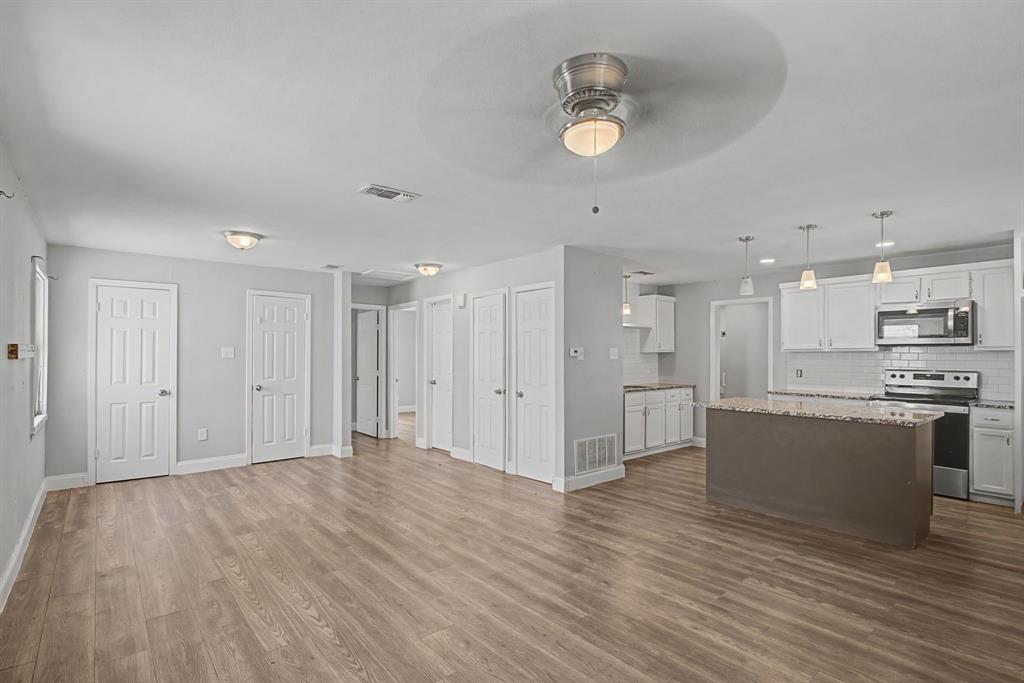 2508 Hillglenn Road Dallas, TX 75228 - Photo 17 of 26 a big room with wooden floor and kitchen view