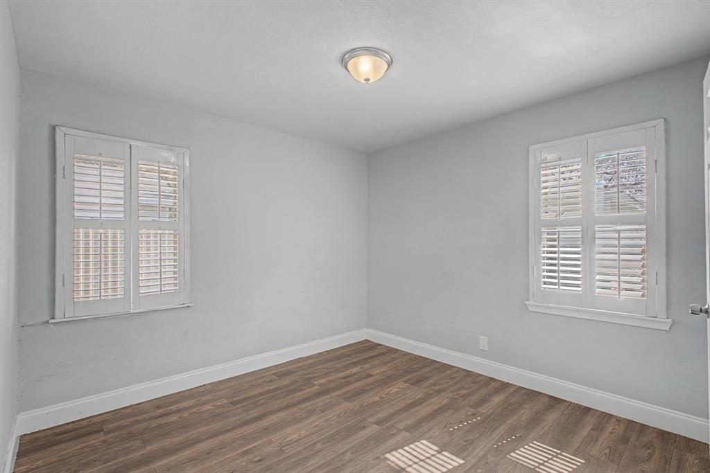 2508 Hillglenn Road Dallas, TX 75228 - Photo 19 of 26 a view of an empty room with wooden floor and a window