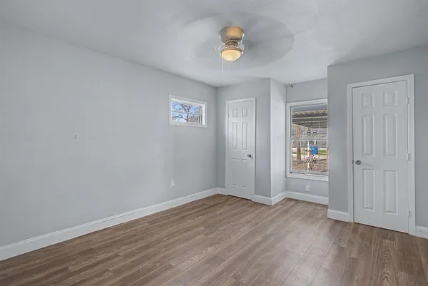 an empty room with wooden floor and window