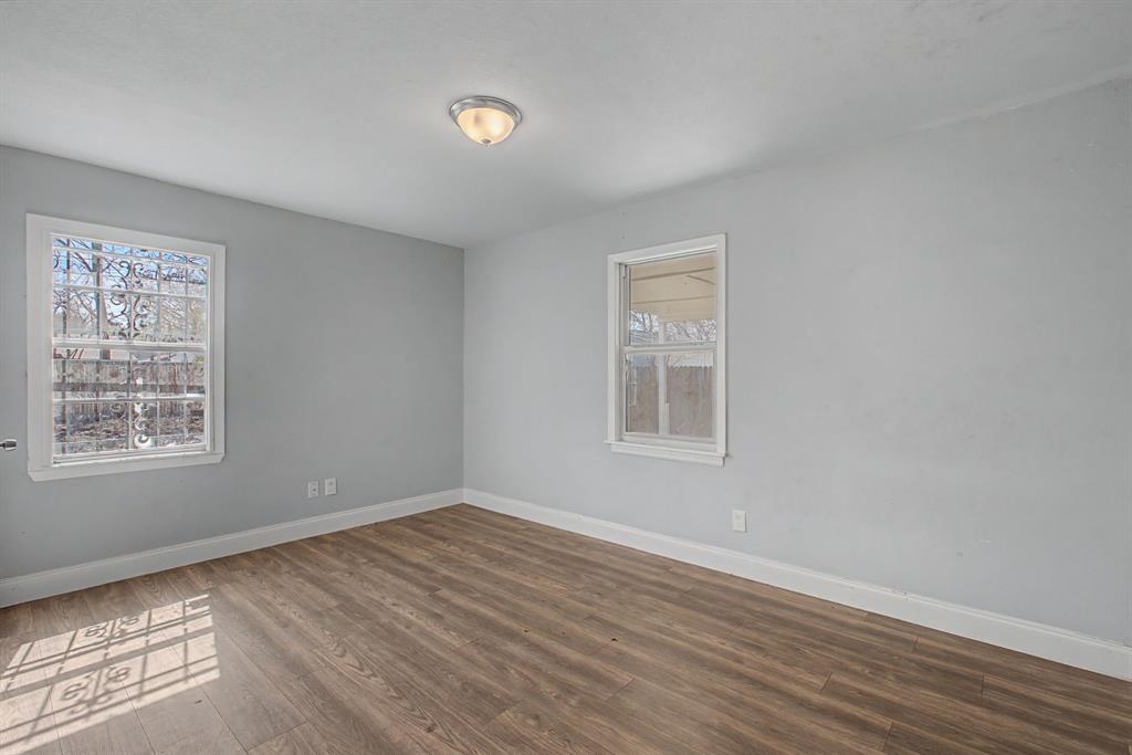 2508 Hillglenn Road Dallas, TX 75228 - Photo 23 of 26 a view of an empty room with wooden floor and a window