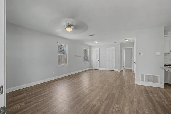 a view of an empty room with wooden floor