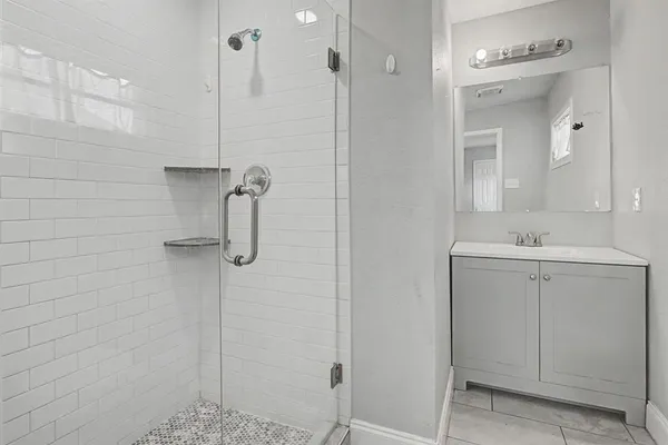 a bathroom with a shower sink and mirror