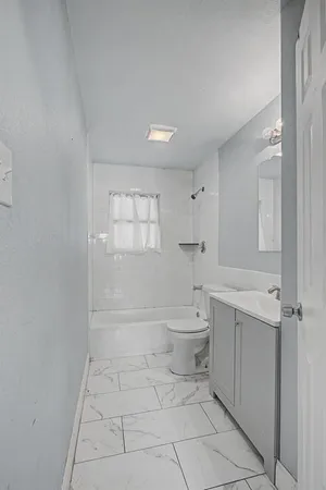 a bathroom with a toilet a sink and bathtub