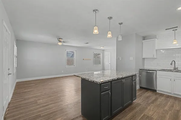 a kitchen with a sink cabinets and wooden floor