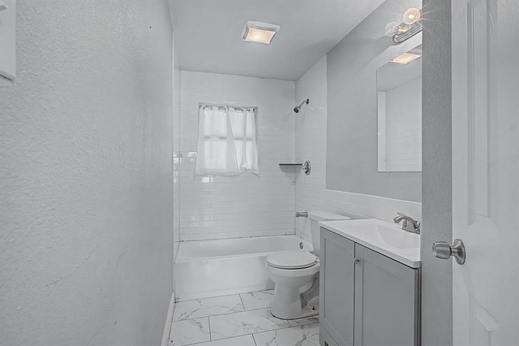 2508 Hillglenn Road Dallas, TX 75228 - Photo 6 of 26 a bathroom with a toilet sink and shower