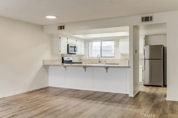 a view of kitchen with stainless steel appliances granite countertop a refrigerator and a sink