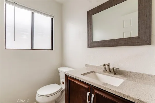 a bathroom with a toilet a sink a vanity and mirror