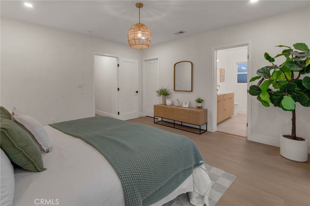 3682 Buckingham Road Los Angeles, CA 90016 - Photo 21 of 30 a spacious bedroom with bed and a potted plant