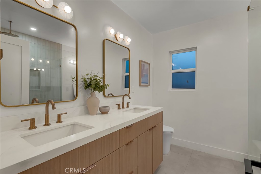 3682 Buckingham Road Los Angeles, CA 90016 - Photo 22 of 30 a bathroom with double vanity sinks and a mirror