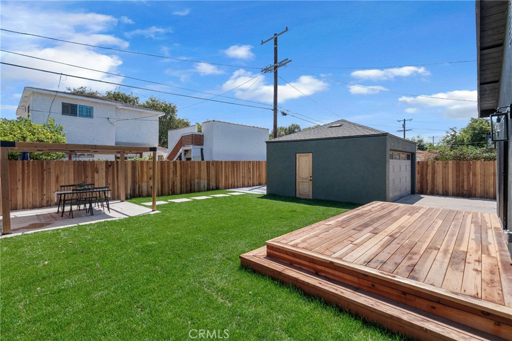 3682 Buckingham Road Los Angeles, CA 90016 - Photo 26 of 30 a view of a backyard with table and chairs with wooden fence
