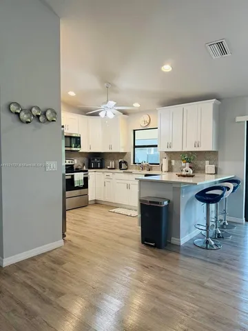 a kitchen with kitchen island a counter top space a sink stainless steel appliances and cabinets