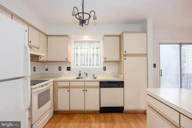 a kitchen with a sink a stove a refrigerator and cabinets