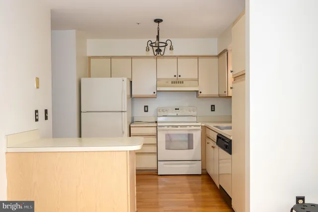 a kitchen with a sink a refrigerator and white cabinets