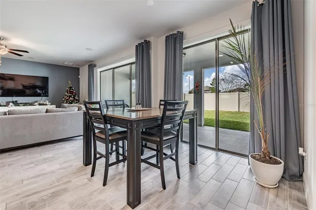 a kitchen with stainless steel appliances a table and chairs in it