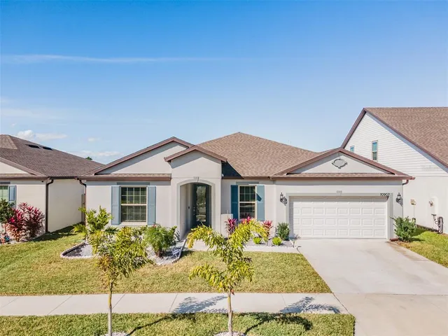 a front view of a house with a garden and plants