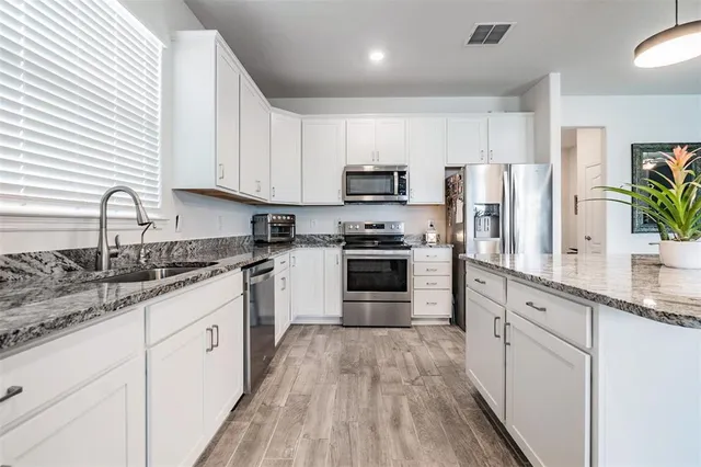 a spacious bedroom with a bed and wooden floor