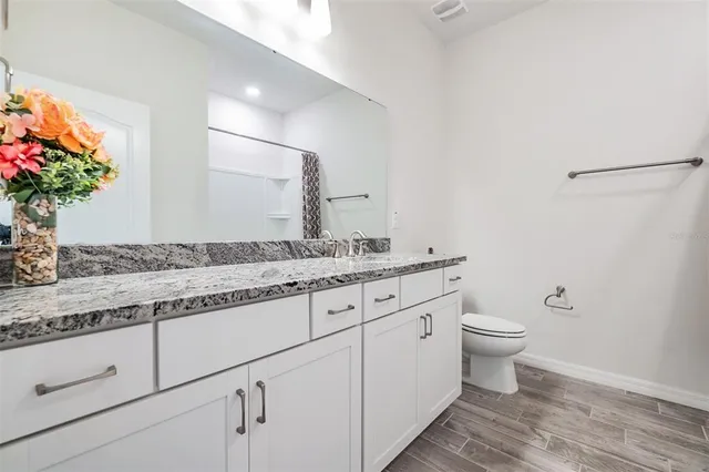 a bathroom with a granite countertop sink mirror and shower