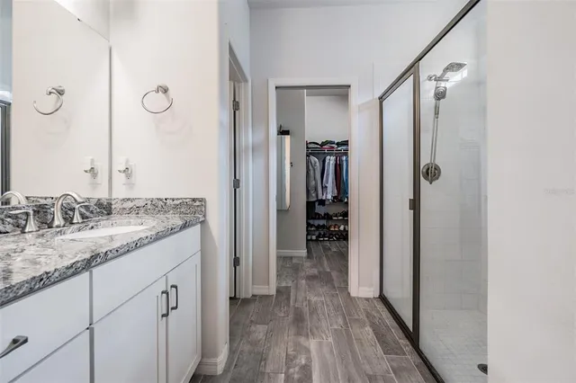 a bathroom with a granite countertop sink and a mirror
