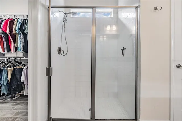 a bedroom with a bed a chair and a chandelier