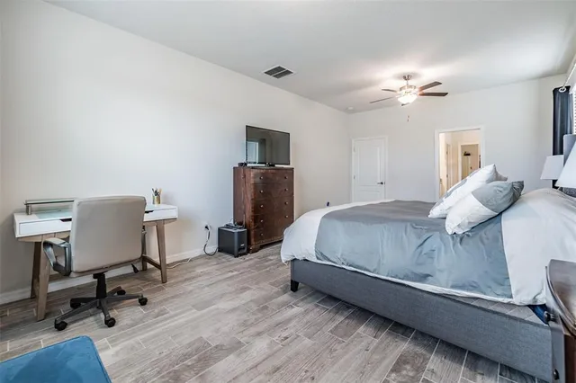 a bedroom with a bed flat screen tv closet and a large window