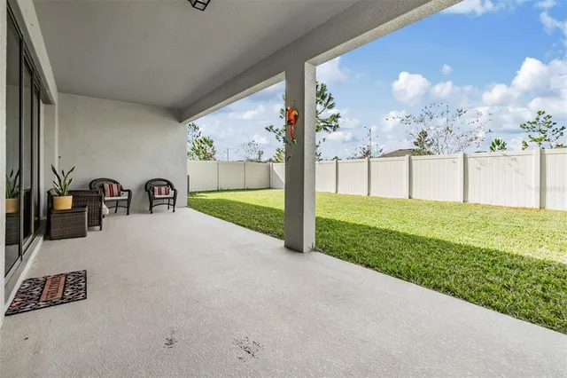 a living room with patio furniture and a garden