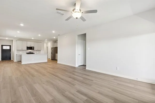 a view of kitchen with refrigerator stove and wooden floor