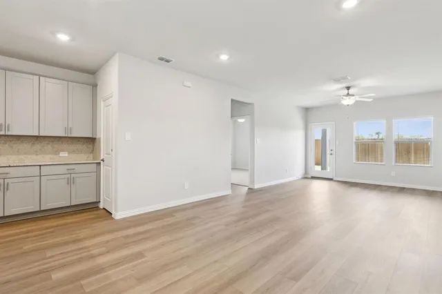 a view of a kitchen with a sink and dishwasher with wooden floor