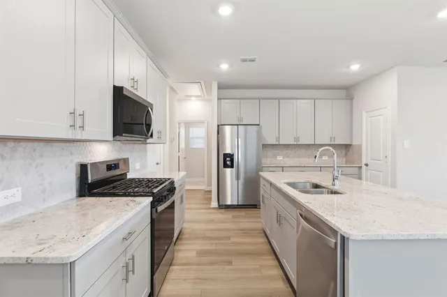 a kitchen with sink a microwave and cabinets