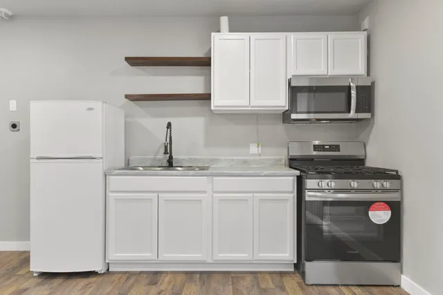 a kitchen with stainless steel appliances granite countertop a stove a microwave and a refrigerator