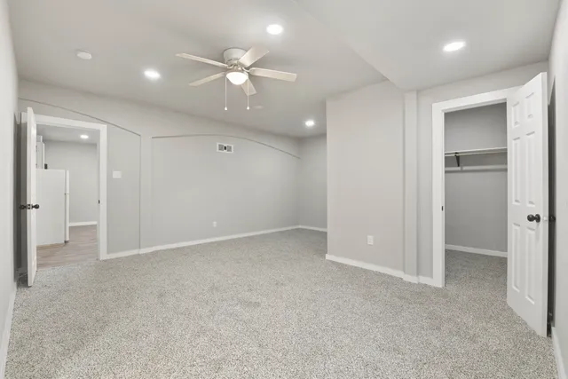 an empty room with fan and entrance