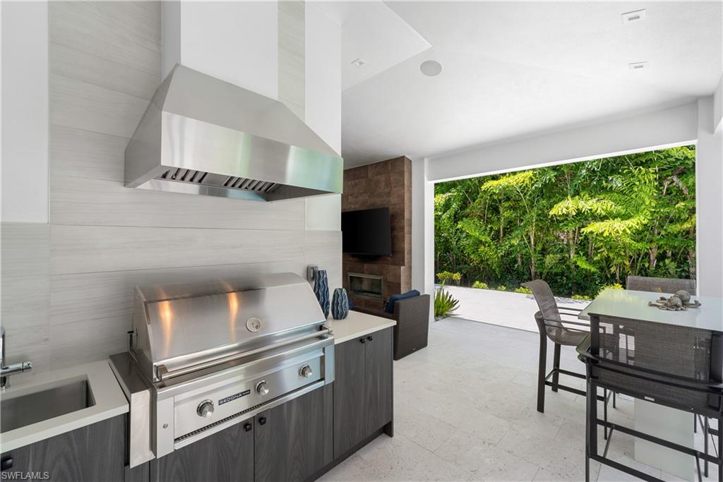 470 Wedge Drive Naples, FL 34103 - Photo 12 of 28 a kitchen with a stove and chairs