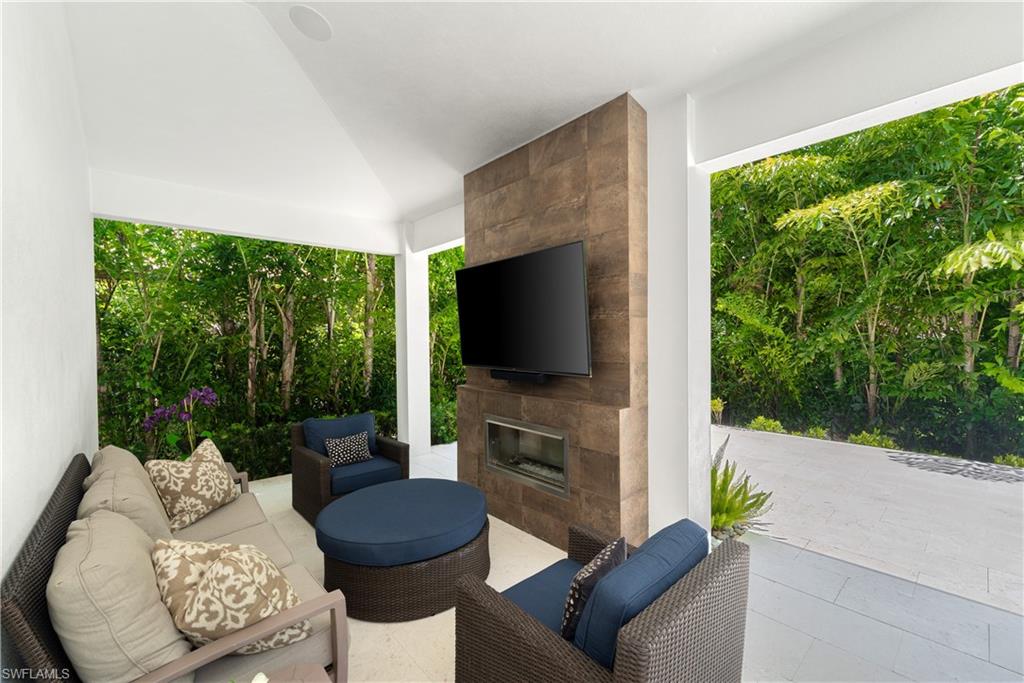 470 Wedge Drive Naples, FL 34103 - Photo 13 of 28 a living room with furniture a flat screen tv and a floor to ceiling window