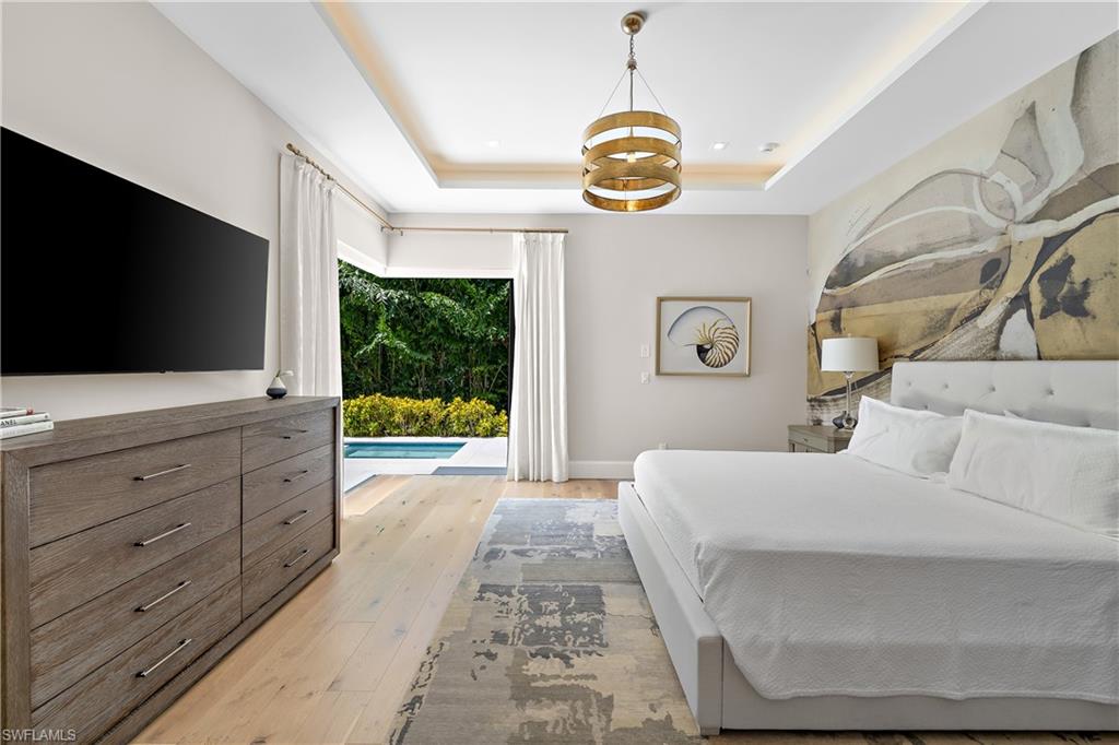 470 Wedge Drive Naples, FL 34103 - Photo 17 of 28 a spacious bedroom with a bed and a flat screen tv