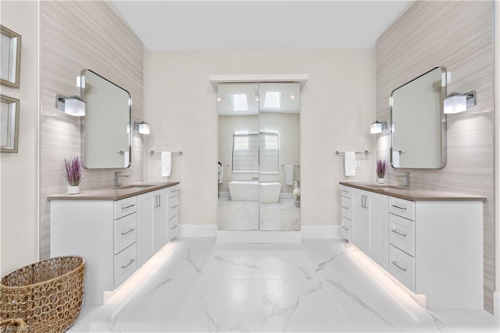 470 Wedge Drive Naples, FL 34103 - Photo 19 of 28 a large white bathroom with a granite countertop sink mirror and