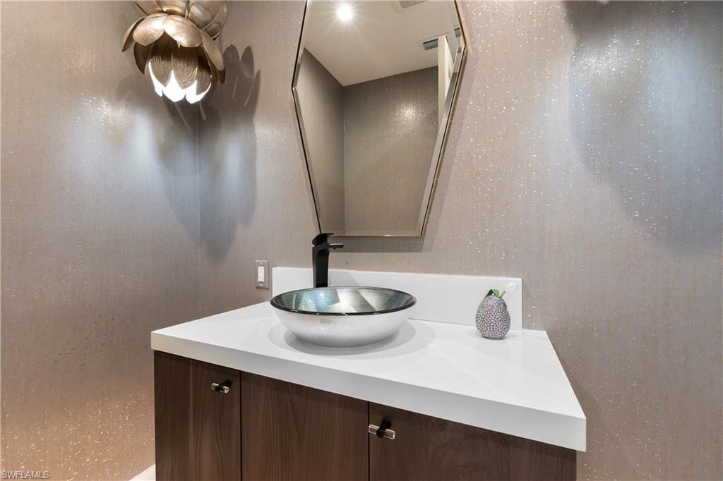 470 Wedge Drive Naples, FL 34103 - Photo 21 of 28 a bathroom with a sink and a mirror