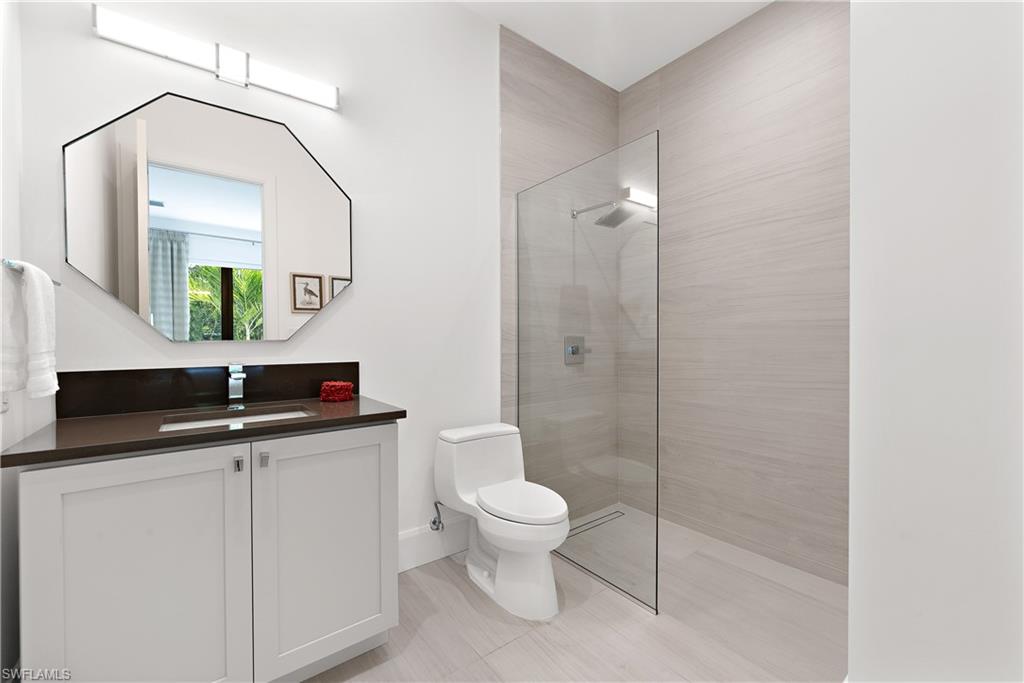 470 Wedge Drive Naples, FL 34103 - Photo 26 of 28 a bathroom with a granite countertop sink a toilet and a mirror