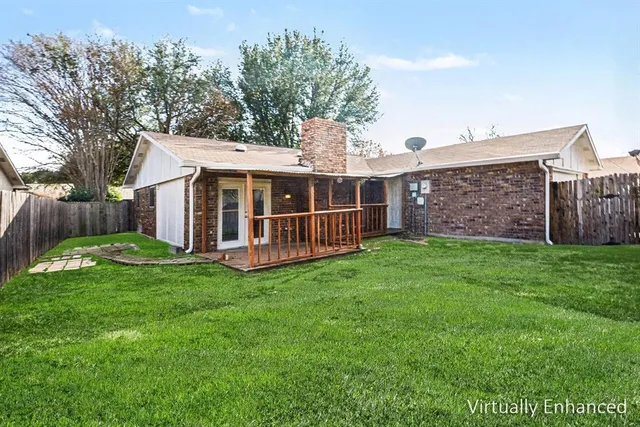 a view of a house with a yard and a large tree