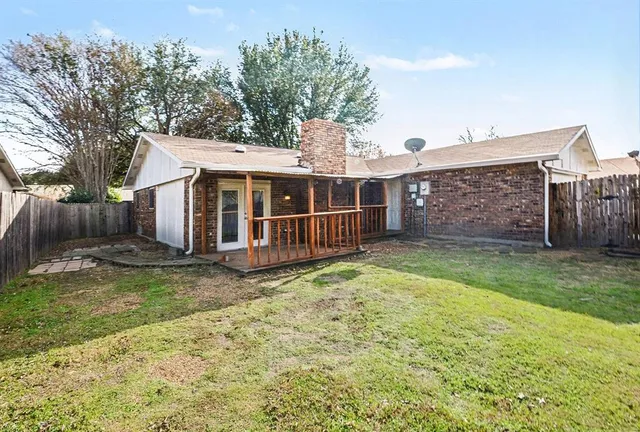 a view of a house with a yard and a large tree