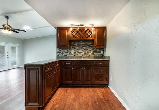 a kitchen with a sink and wooden floor