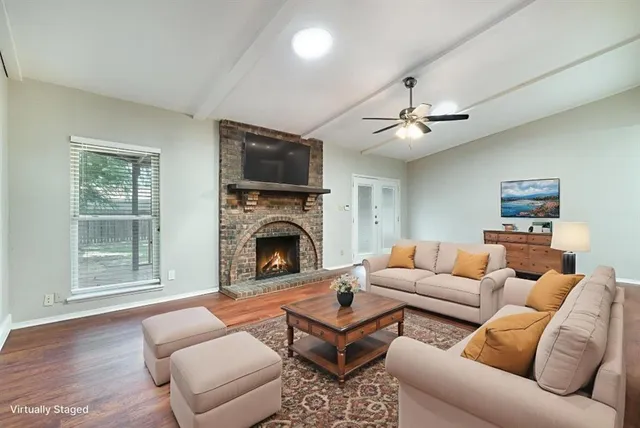 a living room with furniture a fireplace and a flat screen tv